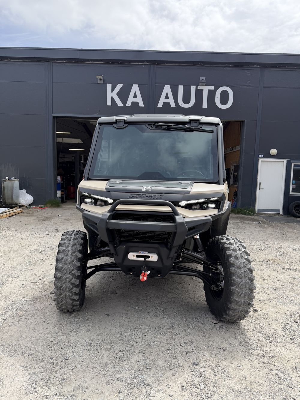 Can-Am Defender med lukket førerhus foran KA Autos værksted i Qaqortoq